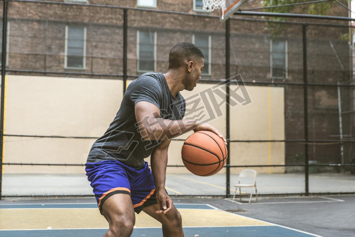 Afro-american basketball player training on a court in New York - Sportive man playing basket outdoo