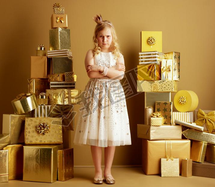 Full length portrait of furious young girl in beige fit and flare dress and a little crown on head s