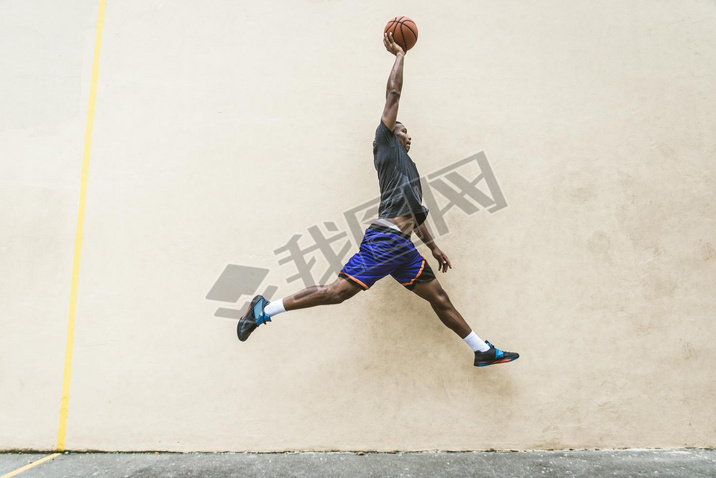 Afro-american basketball player training on a court in New York - Sportive man playing basket outdoo