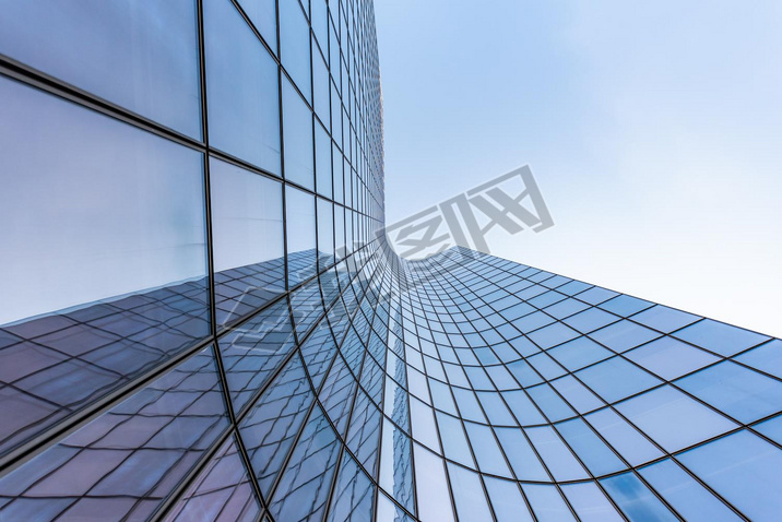 Blue curved glass skyscraper facade against sky