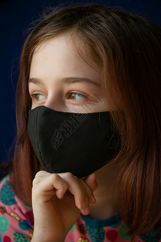 戴着黑色呼吸面具的女孩验尸官，一个戴着蓝色背景面具的女孩。标题关于日冕病毒在中国的爆发，疾病。流行病。青少年，验尸官。病毒。面具