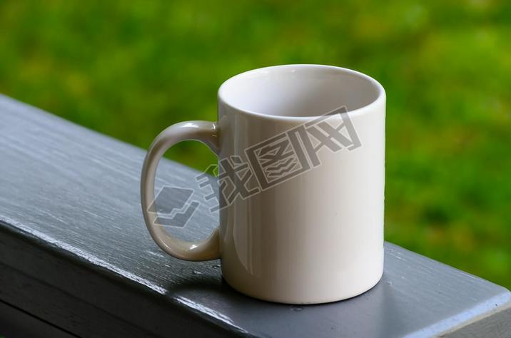 Single white coffee mug on a backyard porch railing