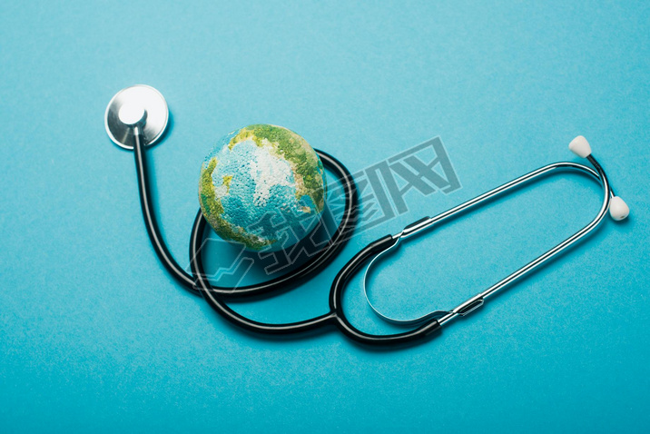 Globe and stethoscope on blue background, world health day concept
