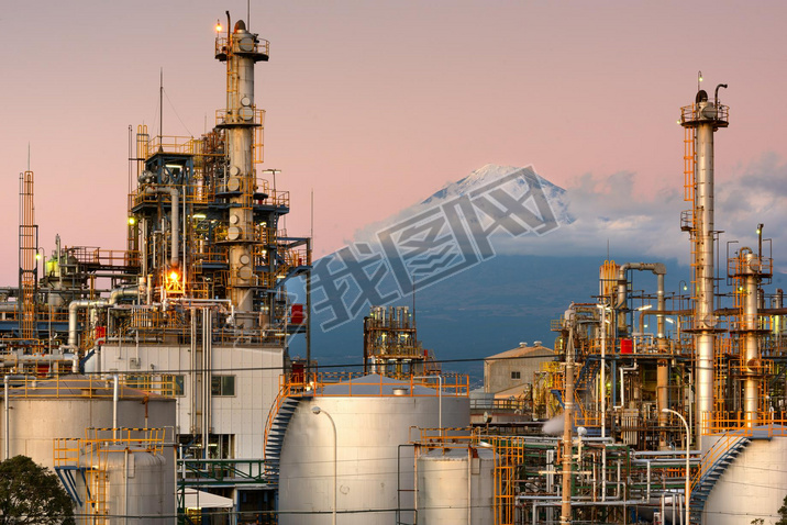 Mt. Fuji, Japan as viewed from behind factories at dusk.