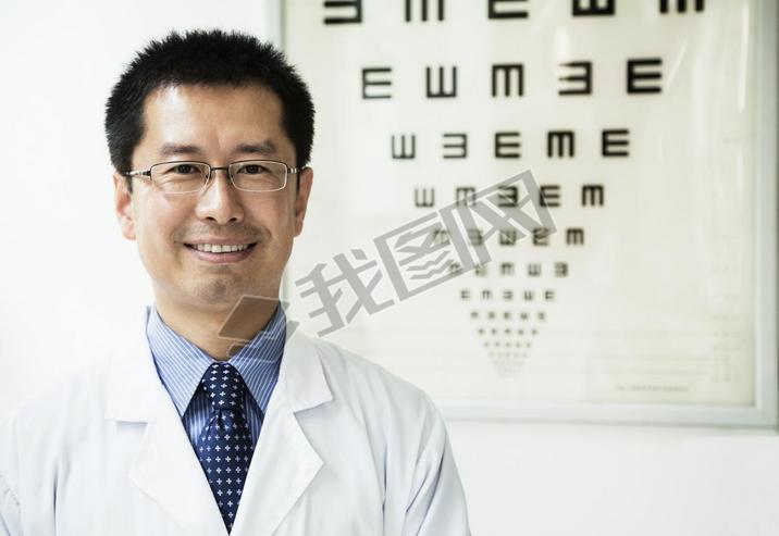 Optometrist with an eye chart in the background