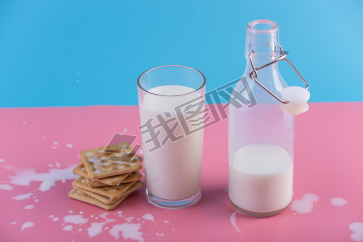 Glass bottle of fresh milk and cookies on pastel background. Colorful minimali. The concept of hea