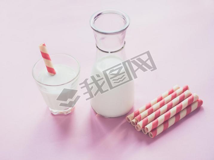 bottle of milk and glass of milk on pink background.