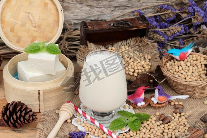 Soy milk and soybeans on wood background.