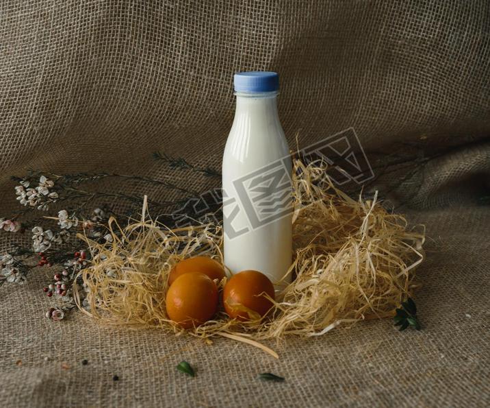 bottle of milk and eggs. rustic style on burlap background