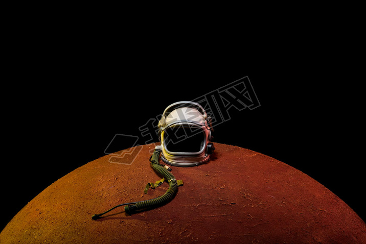 helmet from spacesuit lying on mars planet in black universe