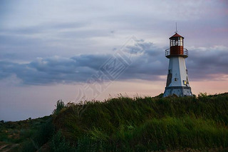 Beautiful lighthouse standing on a hill above the sea.
