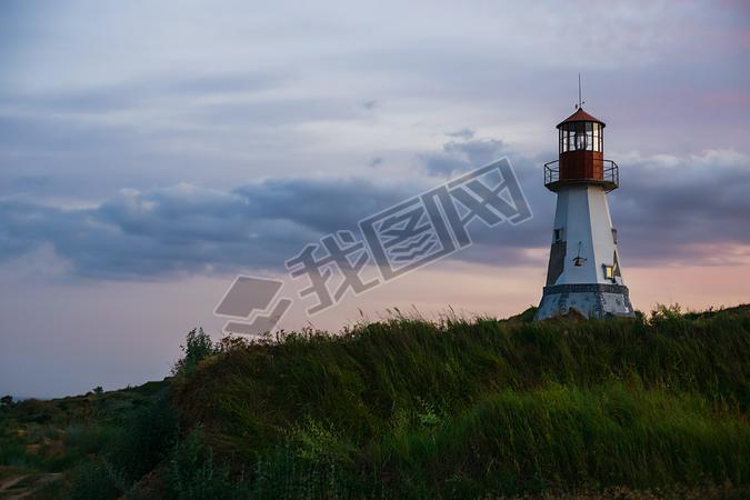 Beautiful lighthouse standing on a hill above the sea.