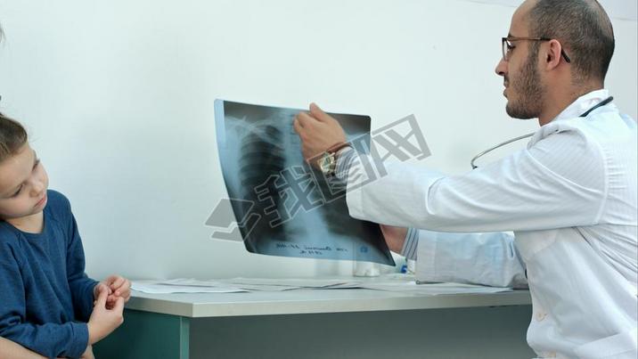 Doctor explaining chest xray image to mother with little daughter