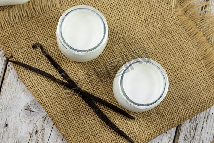 Yoghurt in glass jars on a cloth napkin.