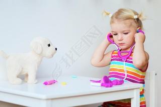 Little girl playing doctor with toy puppy