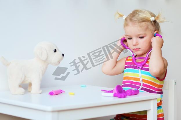 Little girl playing doctor with toy puppy