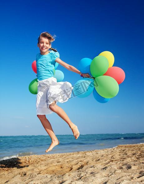 Child playing with balloons at the beach