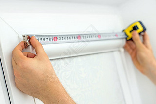 Man installing cassette roller blinds on windows.