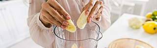 panoramic shot of woman putting sliced bananas into blender