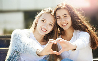 Two Teenagers Holding Hands in Shape of Heart