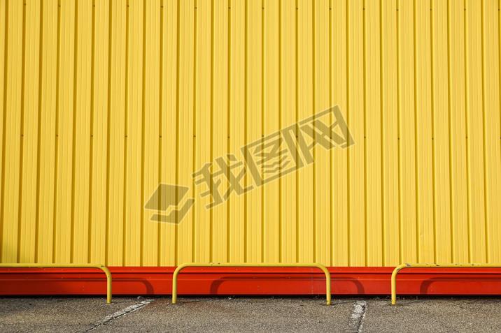 Detail of bright yellow metal building facade. For background