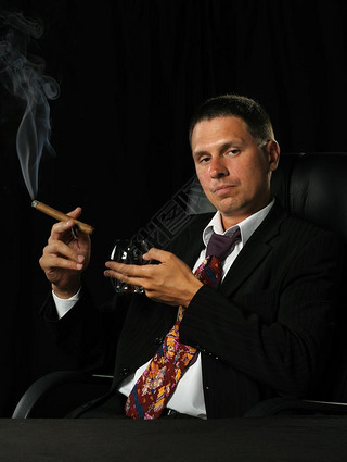 The man with a cigar and a glass of cognac