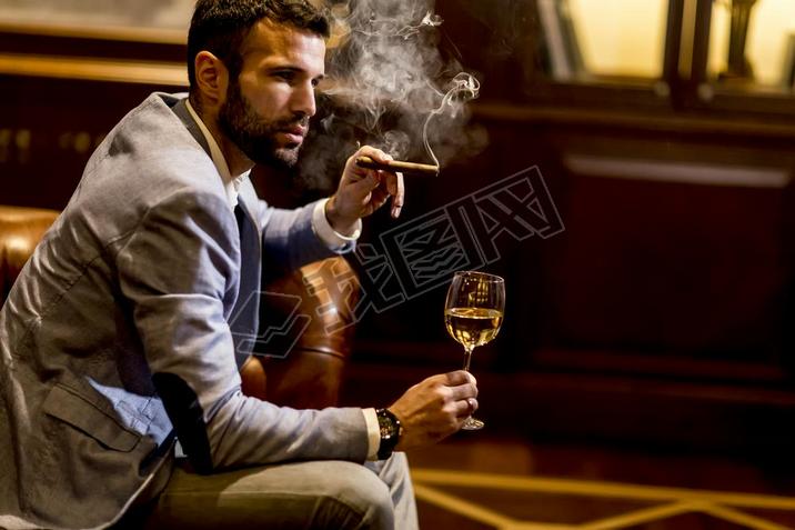 Man tasting wine and oking cigar