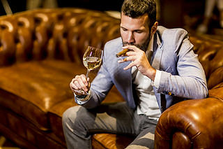 Man tasting wine and oking cigar