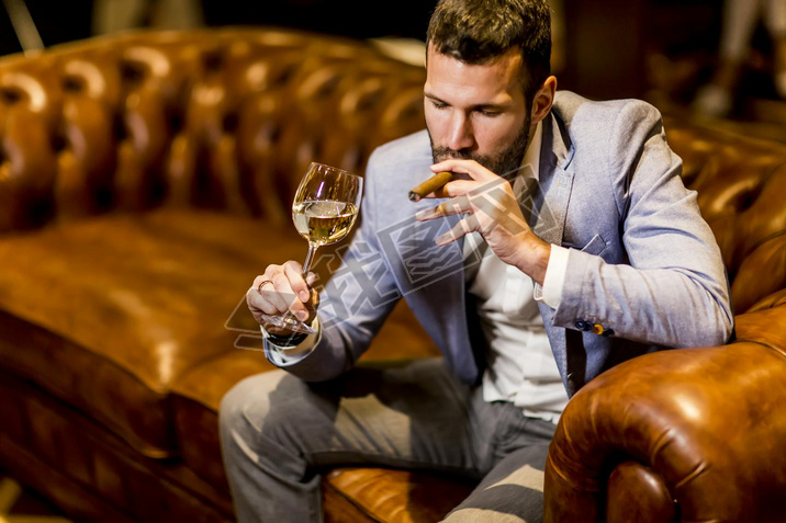 Man tasting wine and oking cigar