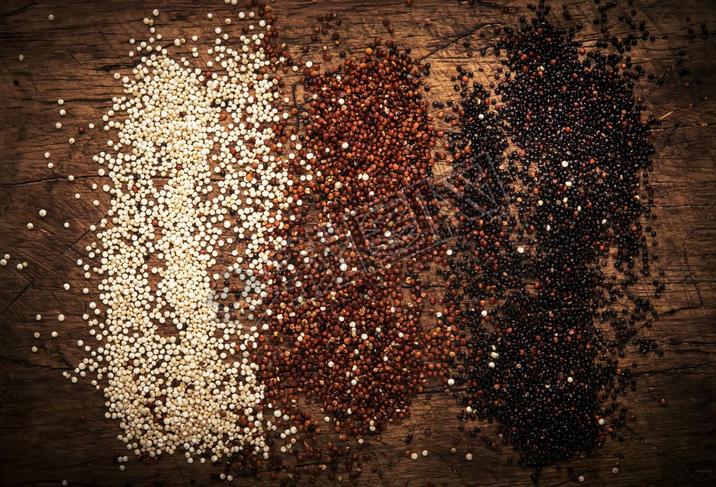 Quinoa set. Black, white and red raw quinoa grains in bowls, groats assorted, wooden rustic kitchen 