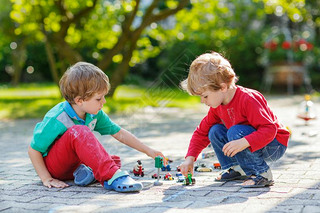 Two little boys playing with car toys
