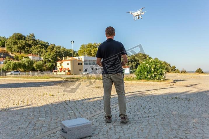 Man, an engineer pilot, a drone, prepares air device for take-off, for testing and filming a vileo a