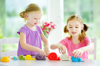 sisters  with colorful modeling clay