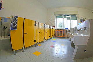 clean toilets of the school and ceramic sinks and yellow doors without the kids and a bright window