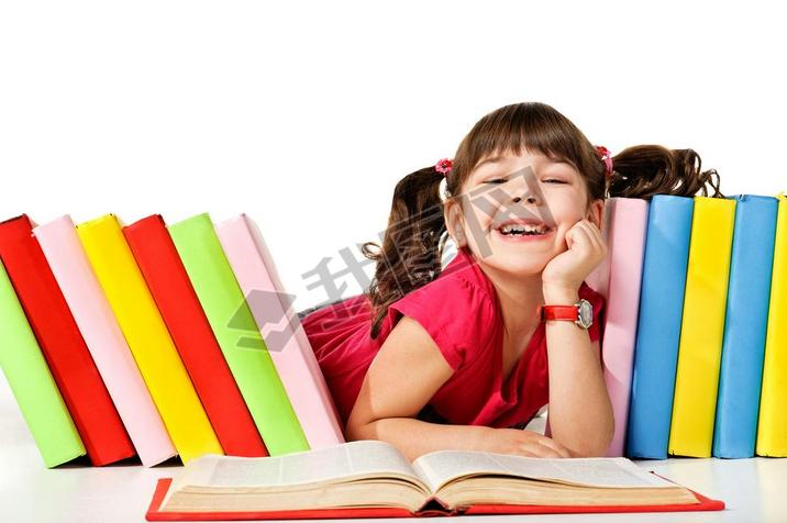 Happy little girl reading a book on the floor