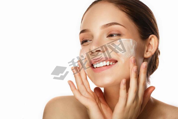 Young woman with moisturizing facial mask on white background. 