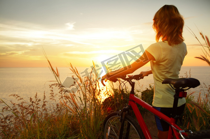 Young lady standing with bicycle