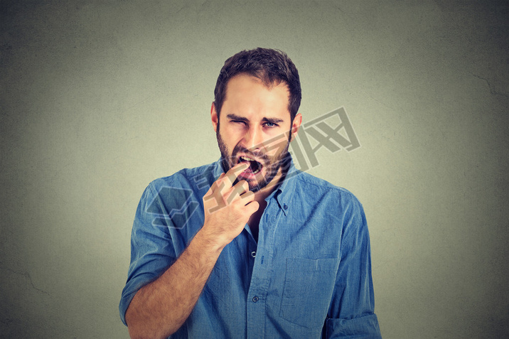 disgusted man with finger in mouth displeased with situation ready to throw up