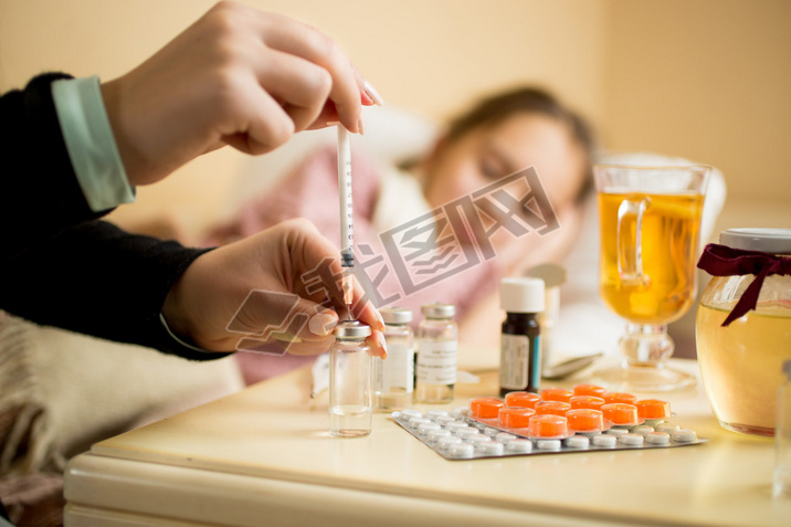 Macro shot of woman filling syringe from ampule