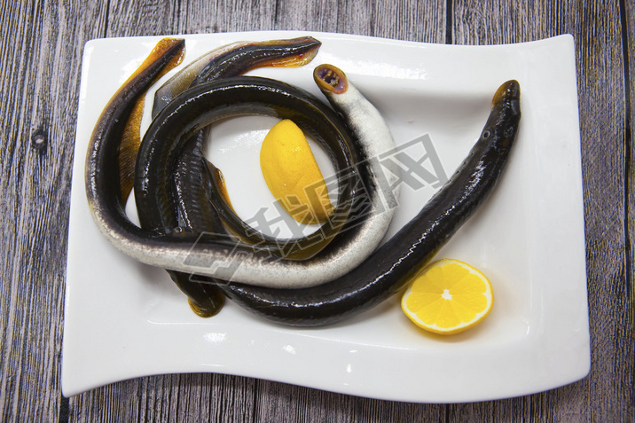 Fresh live fish lamprey on porcelain plate with lemon.