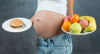 Close up of a cute pregnant belly tummy and healthy food. Pregna