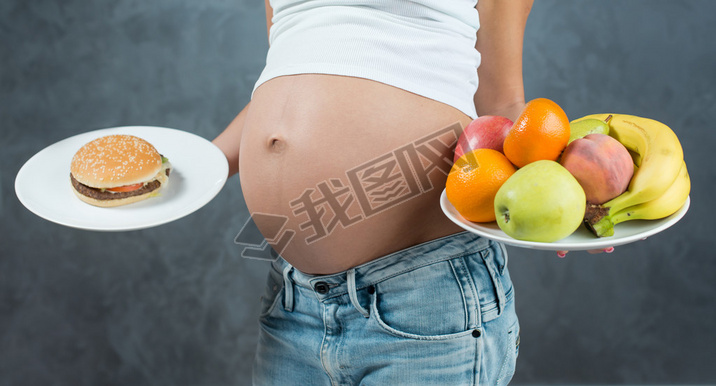 Close up of a cute pregnant belly tummy and healthy food. Pregna