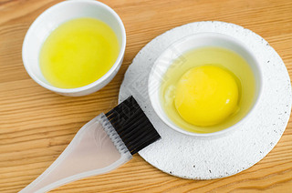 Raw egg and olive oil in a all ceramic bowls for preparing homemade face and hair masks. Ingredien