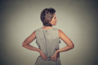 young woman standing with backache back pain