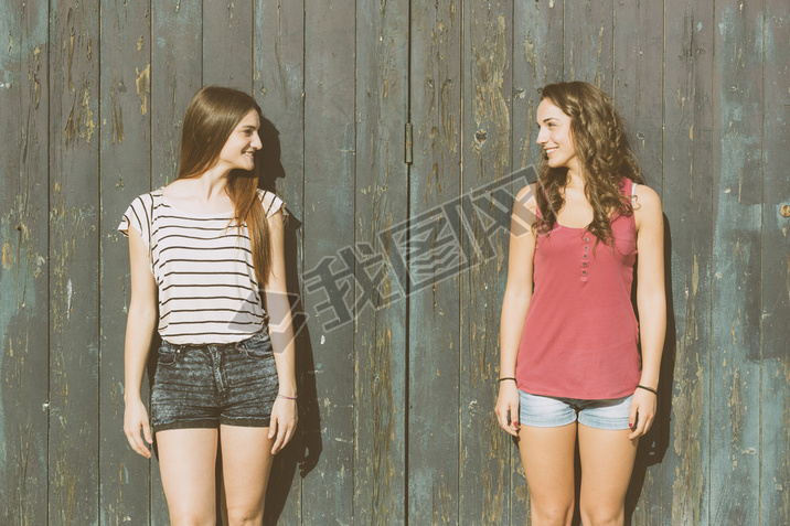 Portrait of two beautiful girls with wooden background