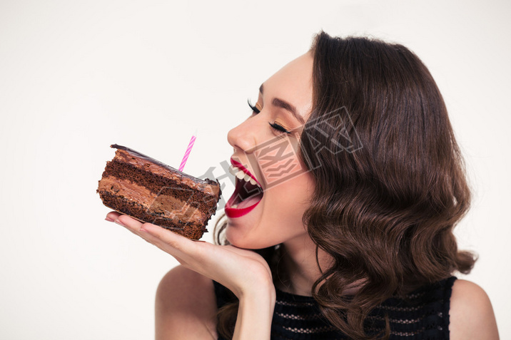 Positive beautiful woman biting piece of chocolate birthday cake