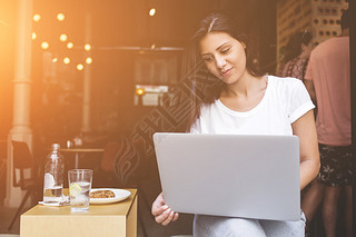 Young female student using laptop computer for learning while sitting in cafe