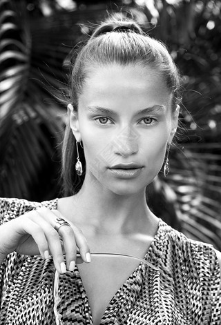 Portrait of beautiful fashion woman in tropics with black sunglasses. Sexy girl wearing color overal