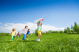 Children run after boy holding rocket