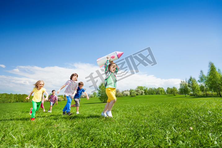 Children run after boy holding rocket